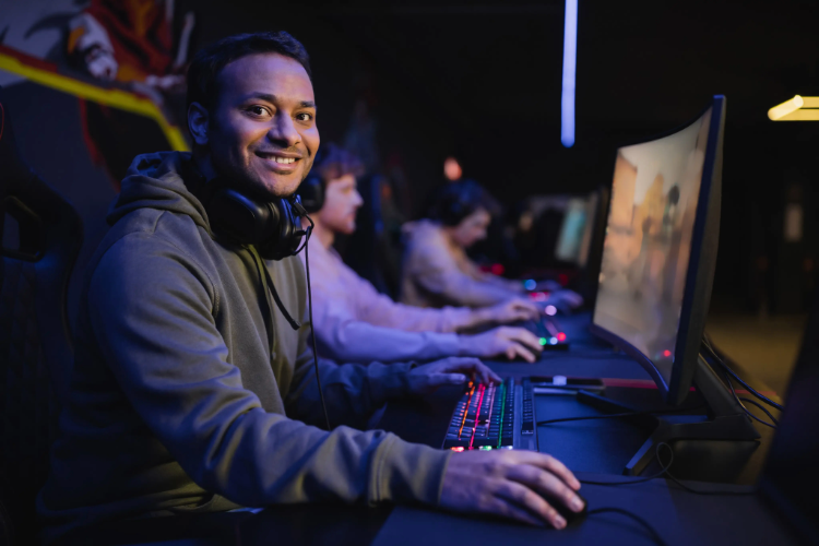 smiling-indian-gamer-looking-at-camera-near-comput-2026-01-05-23-47-24-utc smiling-indian-gamer-looking-at-camera-near-comput-2026-01-05-23-47-24-utc